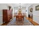 Elegant dining room featuring a large wooden table and chairs, plus a patterned area rug at 1412 Kings Lassiter Way, Raleigh, NC 27614
