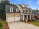 Traditional two-story home with a two-car garage and welcoming front porch at 1412 Kings Lassiter Way, Raleigh, NC 27614