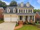 Inviting two-story home with a spacious two-car garage, a brick walkway and a cozy front porch at 1412 Kings Lassiter Way, Raleigh, NC 27614