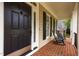 Inviting front porch featuring rocking chairs, a brick floor, and a front door at 1412 Kings Lassiter Way, Raleigh, NC 27614