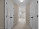 Hallway with carpeting and white closet doors on either side leading to the bathroom at 1412 Kings Lassiter Way, Raleigh, NC 27614
