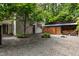 Gravel backyard with firewood storage and mature trees offering shade and privacy at 145 Ryan Rd, Pittsboro, NC 27312