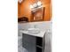 Updated bathroom with modern vessel sink, gray vanity, and contrasting orange accent wall at 145 Ryan Rd, Pittsboro, NC 27312