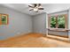A serene bedroom with hardwood floors, a ceiling fan, and a window providing views of the surrounding greenery at 145 Ryan Rd, Pittsboro, NC 27312