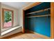 Closet with wooden shelves, blue accent wall, and window view at 145 Ryan Rd, Pittsboro, NC 27312