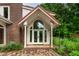 Elegant entryway with grand columns and arched windows, surrounded by vibrant flowers at 145 Ryan Rd, Pittsboro, NC 27312