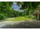 Scenic view of property with a driveway and manicured lawn, nestled in lush trees at 145 Ryan Rd, Pittsboro, NC 27312