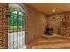 Inviting living room featuring a brick accent wall, wood-burning stove, and iron gate entryway at 145 Ryan Rd, Pittsboro, NC 27312