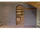Brick archway leads to kitchen from the living room, with brick accent wall and coat rack on the right at 145 Ryan Rd, Pittsboro, NC 27312