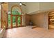 Bright sunroom with wood stove, brick accent wall, arched doorway, large windows, and French doors to the yard at 145 Ryan Rd, Pittsboro, NC 27312