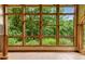 Sunroom with large grid windows providing expansive views of the lush green landscaping and mature trees at 145 Ryan Rd, Pittsboro, NC 27312