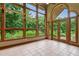 Sunroom features large grid windows, french doors to the yard, tile flooring, and views of surrounding landscape at 145 Ryan Rd, Pittsboro, NC 27312