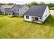 The spacious backyard offers a large lawn and a covered patio with a modern home design at 173 Little Creek Dr, Lillington, NC 27546