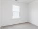 A bright bedroom featuring a large window, bright white walls and neutral carpet at 173 Little Creek Dr, Lillington, NC 27546