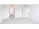 A bright bedroom with neutral carpet, white walls, and multiple access doors at 173 Little Creek Dr, Lillington, NC 27546