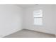 A sunny bedroom with a large window, bright white walls and neutral carpet at 173 Little Creek Dr, Lillington, NC 27546