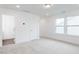 Bedroom with a double window, bright white walls, neutral carpet and a paneled door at 173 Little Creek Dr, Lillington, NC 27546