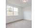 Light-filled bedroom with plush carpet and a large window overlooking the surrounding landscape at 173 Little Creek Dr, Lillington, NC 27546
