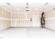 Spacious two-car garage with concrete flooring and door to access the water heater at 173 Little Creek Dr, Lillington, NC 27546