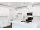 Bright, all-white kitchen featuring modern appliances and a spacious island with a sink at 173 Little Creek Dr, Lillington, NC 27546