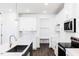 A modern, all-white kitchen with stainless steel appliances and a view into the mudroom at 173 Little Creek Dr, Lillington, NC 27546