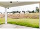 Covered patio with concrete floor overlooking an open backyard with new construction homes in the background at 173 Little Creek Dr, Lillington, NC 27546