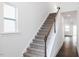 Carpeted staircase with white railing and wooden banister, leading to the upper level of the home at 173 Little Creek Dr, Lillington, NC 27546