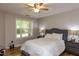 Cozy bedroom with a ceiling fan, warm lighting, and large windows for natural light at 1911 Falls Landing Dr # 103, Raleigh, NC 27614