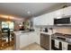 Bright kitchen with white cabinets, stainless steel appliances, and open view to the dining area at 1911 Falls Landing Dr # 103, Raleigh, NC 27614