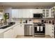 Bright kitchen features white cabinets, stainless steel appliances, and quartz countertops at 1911 Falls Landing Dr # 103, Raleigh, NC 27614