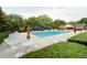 Community pool with lounge chairs and umbrellas surrounded by lush green landscaping at 1911 Falls Landing Dr # 103, Raleigh, NC 27614