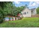 An immaculate back yard with pool, chairs, landscaping, and privacy trees at 2328 Forestbluff Dr, Fuquay Varina, NC 27526