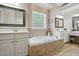 Bright bathroom featuring a jacuzzi tub, and separate vanities at 2328 Forestbluff Dr, Fuquay Varina, NC 27526