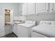 Well-lit laundry room with white cabinets, a sink, countertop space, and appliances ready for laundry at 2328 Forestbluff Dr, Fuquay Varina, NC 27526