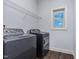 Bright laundry room with a window, shelving, and modern washer and dryer hookups at 235 Camden Place St, Princeton, NC 27569
