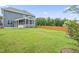 Large, manicured backyard with a covered patio, privacy fence, and lush green grass at 2527 Sidewinder Ct, Apex, NC 27523