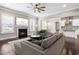Open living room with fireplace, ceiling fan, and view into eat-in kitchen at 2527 Sidewinder Ct, Apex, NC 27523