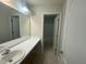 Bathroom features a single sink vanity, a framed mirror, and an adjoined bathroom with a shower-tub combo at 2852 Orchard Trace Way, Raleigh, NC 27610