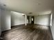 Bright living room features new hardwood floors and fresh paint with a view of the stairwell at 2852 Orchard Trace Way, Raleigh, NC 27610