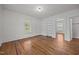 Comfortable bedroom featuring hardwood floors, white walls, and a large window for natural light at 303 N Watauga Ave, Dunn, NC 28334