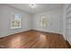 Cozy bedroom featuring hardwood floors, white walls, and ample natural light from the large windows at 303 N Watauga Ave, Dunn, NC 28334
