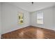 Sunlit bedroom featuring hardwood floors, fresh white walls, and large windows overlooking the street at 303 N Watauga Ave, Dunn, NC 28334
