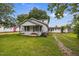 Charming single-story home with a welcoming front porch, beautiful lawn, and American flag at 303 N Watauga Ave, Dunn, NC 28334