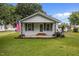 Charming bungalow features a well-manicured lawn, American flag, and a welcoming front porch at 303 N Watauga Ave, Dunn, NC 28334