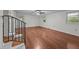 A large, bright living room with hardwood floors, a ceiling fan, and a staircase at 303 N Watauga Ave, Dunn, NC 28334