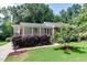 Charming home with white exterior, brick accents, covered porch, and manicured landscaping at 325 Northfield Dr, Raleigh, NC 27609