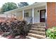 Inviting front porch with stone steps, decorative door, and neatly trimmed landscaping at 325 Northfield Dr, Raleigh, NC 27609