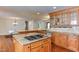 Open kitchen with island cooktop, granite countertops, custom cabinets, and hardwood flooring at 325 Northfield Dr, Raleigh, NC 27609