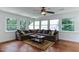 Cozy living room with large windows, plush sofa, hardwood floors, and stylish ceiling fan at 325 Northfield Dr, Raleigh, NC 27609