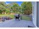 Spacious back deck area with a grill, seating, and a view of the green lawn, perfect for outdoor entertaining at 3713 Highland Creek Dr, Apex, NC 27539